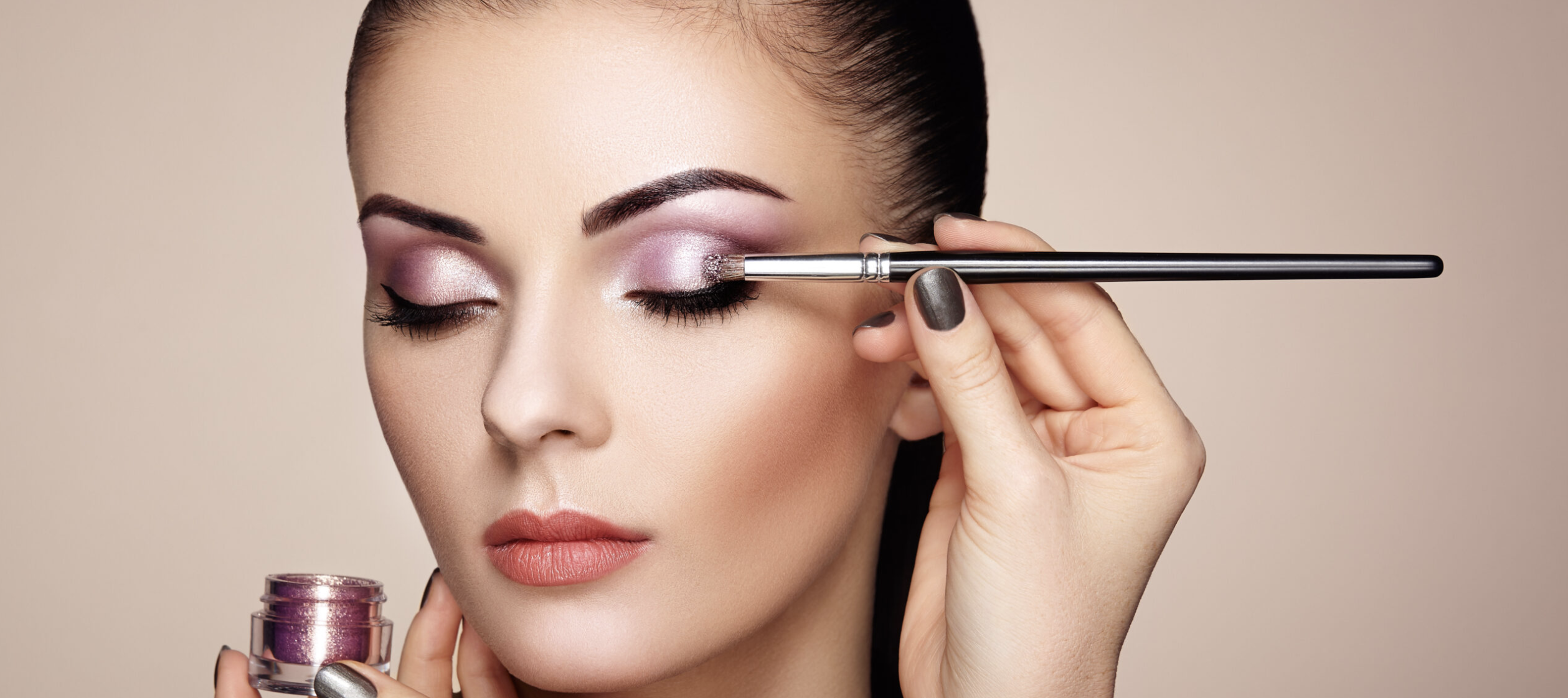 A close-up of a woman applying vibrant eye shadow formulated with BioconColors botanical natural colorants, highlighting safety and high-performance in clean beauty products.