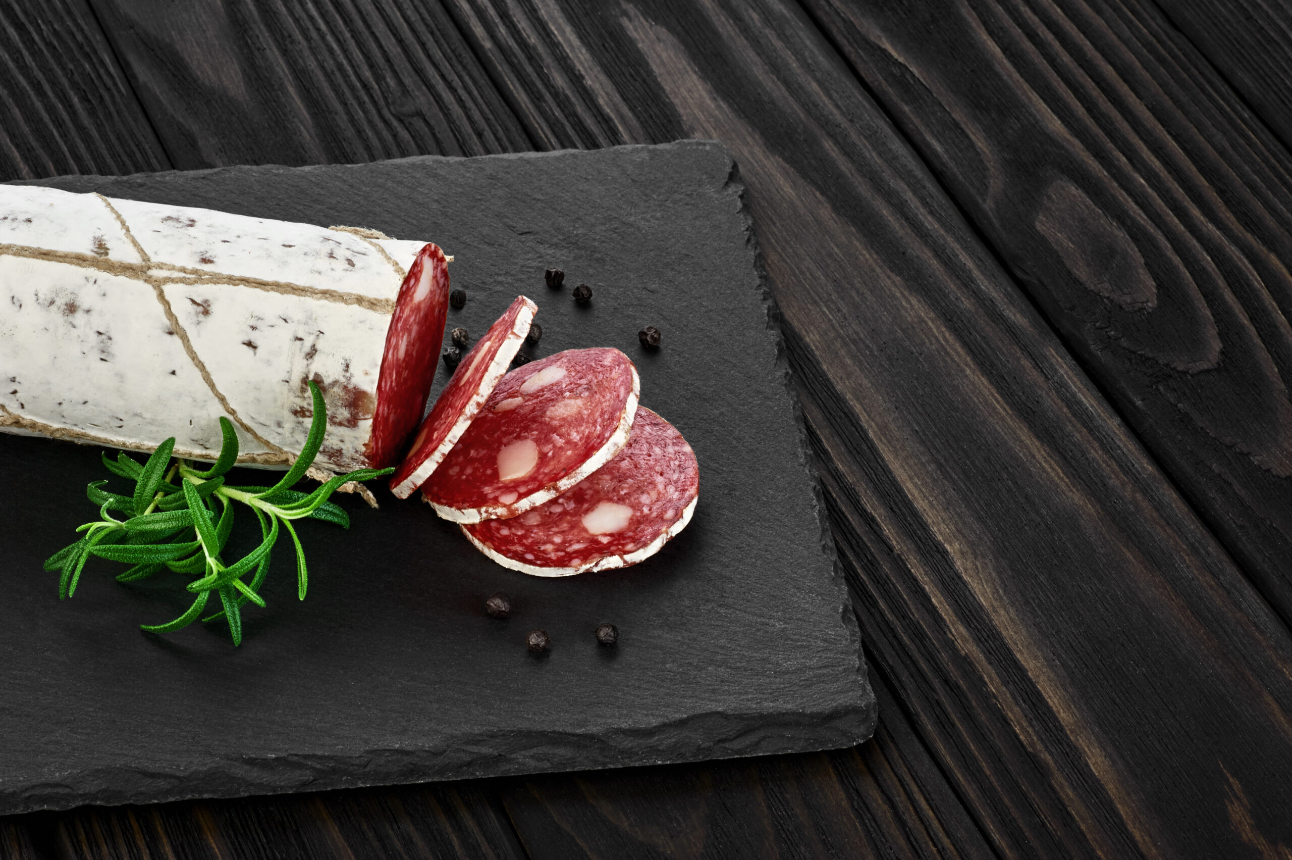 Slices of premium cured salami with a rich, natural red hue, achieved with BioconColors high-stability natural colorant solutions for the meat industry.